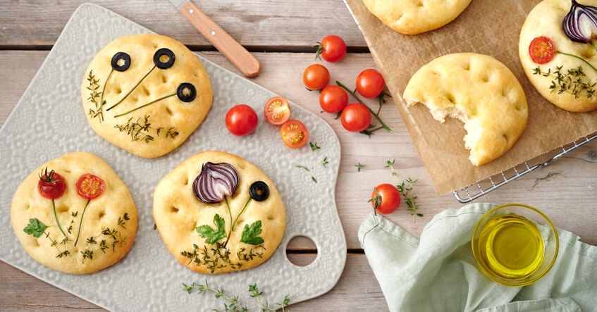 Focaccia Brote auf dem Brett und auf Toppits Backpapier